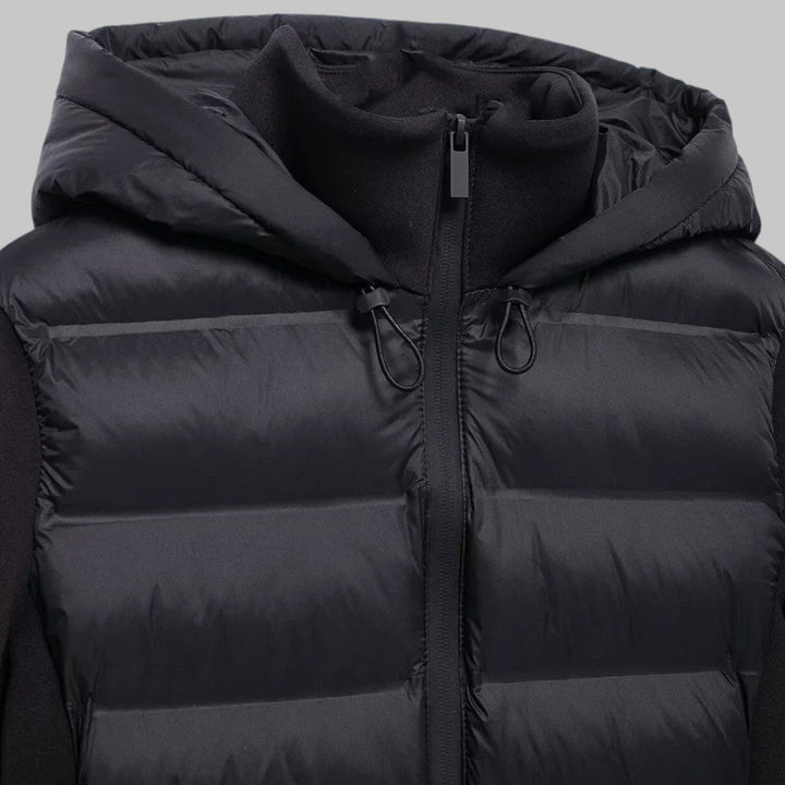Gewatteerd zwart damesjack met capuchon, winddicht en lichtgewicht. Perfect voor het voorjaar en najaar.