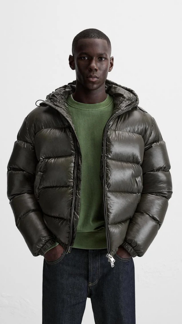 Man poseert in een warm en modieus groen winterjack, klaar voor de koude dagen.