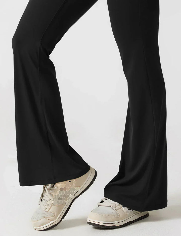 Zwarte dames jumpsuit met shaping, flared pijpen en diepe V-rug.