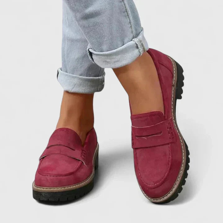 Stijlvolle zwarte dames instappers met grove profielzool en klassieke penny band. Geschikt als werk- of casual schoenen.