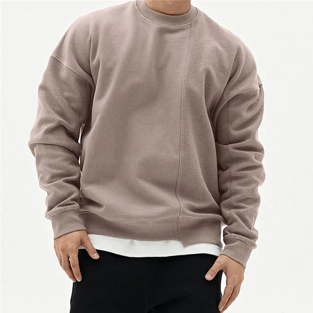 Grijze heren winter sweater met ronde hals. Casual, comfortabel en oversized met opvallende asymmetrische naad.